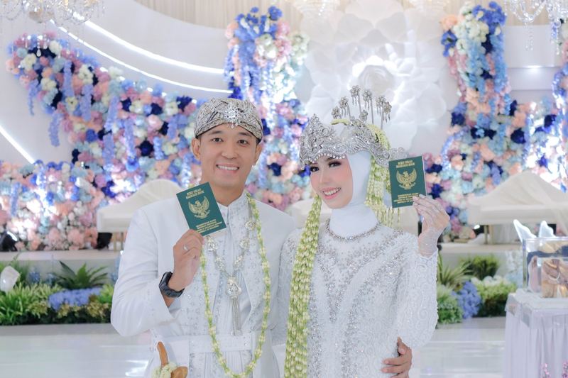 Pengantin memegang buku nikah